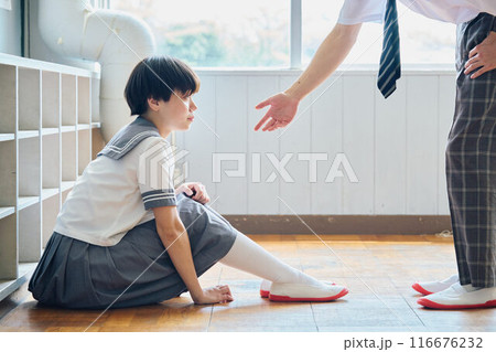 落ち込む女子校生に手を差し伸べる男子高校生 116676232