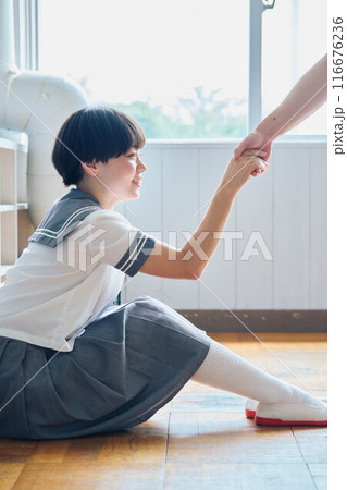 落ち込む女子校生に手を差し伸べる男子高校生 116676236