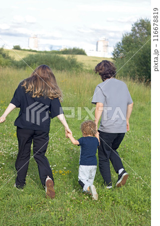 Dad and mum run with child along path in summer in countryside. Nature and sunlight. Sunset. . High quality 4k footage Dad and mum run with child along path in summer in countryside. Nature and sunlight. Sunset. . High quality 4k footage 116678819