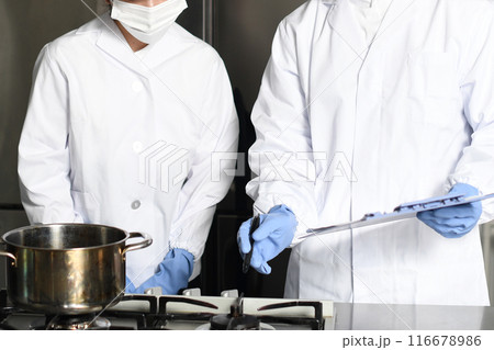 食品系の工場で確認作業をする調理員のアジア人男女 食品系の工場で確認作業をする調理員のアジア人男女 116678986