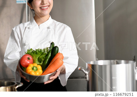 沢山の野菜を持つ若いアジア人の女性調理師 沢山の野菜を持つ若いアジア人の女性調理師 116679251