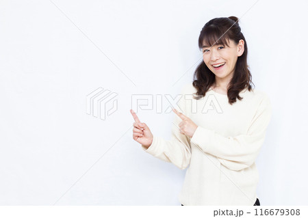 両手で指差しをしている笑顔の女性 両手で指差しをしている笑顔の女性 116679308