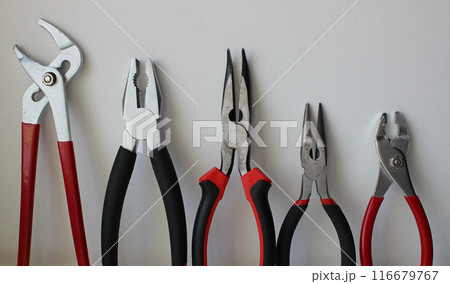 Different Types Of Pliers With Plastic Handles Arranged By Size Isolated On White Background 116679767