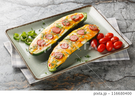Homemade Zucchini stuffed and baked with cheddar and mozzarella cheese, sausage, tomato sauce and spices close-up in a plate. Horizontal 116680400