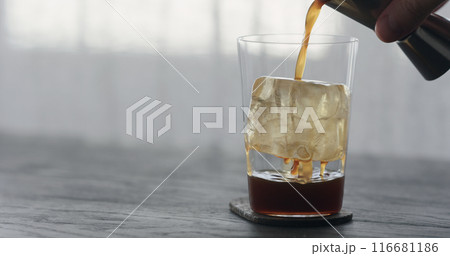 coffee pour over ice cube in tumbler glass on black wood table coffee pour over ice cube in tumbler glass on black wood table 116681186