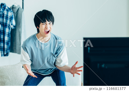 TVを見る若い男性 116681377