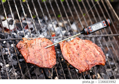 Grilled steak with digital meat thermometer shows medium rare doneness 116683992