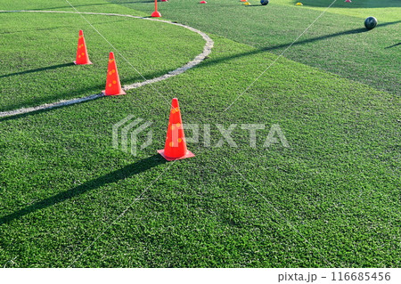 artificial green grass soccer field with orange training cones 116685456