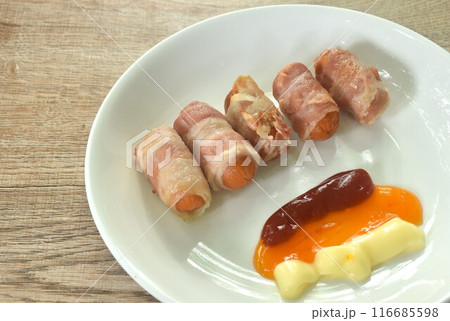 pork sausage roll up bacon dipping mayonnaise and chili sauce with ketchup arranging on plate pork sausage roll up bacon dipping mayonnaise and chili sauce with ketchup arranging on plate 116685598