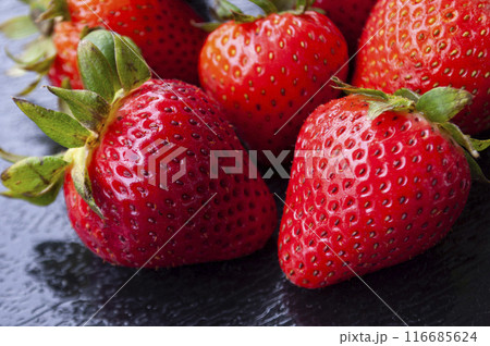 Close up of strawberries on black cover background. Healthy food and fruits concept. 116685624