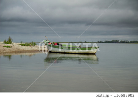 lonely fishing boat docked in calm sea. 116685902