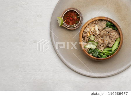 Egg fried rice with Onion, Fried pork, Chinese kale and Cucumber in Wooden bowl. Egg fried rice with Onion, Fried pork, Chinese kale and Cucumber in Wooden bowl. 116686477