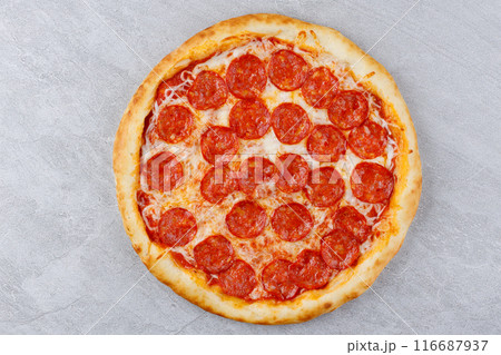 Pepperoni pizza with sausages and cheese mozzarella on a gray concrete countertop. Top view. 116687937