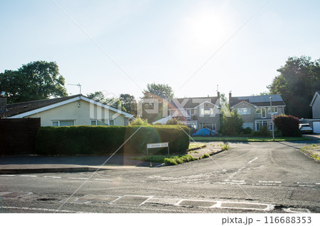 まぶしい朝日が当たるレンガ造りの煙突がある白壁の住宅　南ウェールズの郊外の街並み 116688353