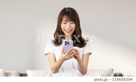 スマホを操作する笑顔の日本人女性 スマホを操作する笑顔の日本人女性 116688394