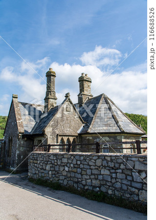 もこもこな雲が浮かぶ青空の下の緑に囲まれた歴史的な石造りの建物　南ウェールズの郊外にて 116688526