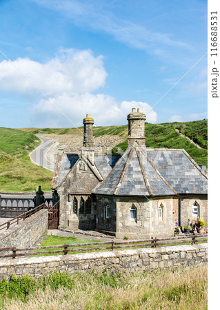 もこもこな雲が浮かぶ青空の下の緑に囲まれた歴史的な石造りの建物　南ウェールズの郊外にて 116688531