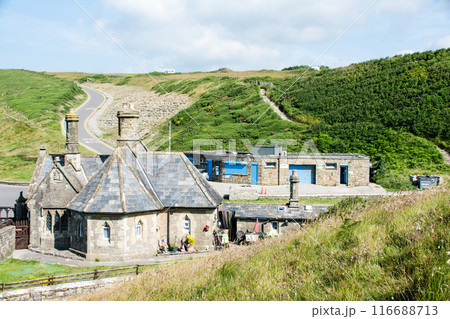 もこもこな雲が浮かぶ青空の下の緑に囲まれた歴史的な石造りの建物 南ウェールズの郊外にて もこもこな雲が浮かぶ青空の下の緑に囲まれた歴史的な石造りの建物 南ウェールズの郊外にて 116688713