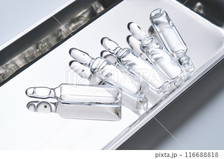 Glass ampoules in a steel medical tray. Glass ampoules in a steel medical tray. 116688818
