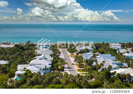 Expensive waterfront houses between green palm trees in Boca Grande, small town on Gasparilla Island in southwest Florida. Premium housing development in the USA Expensive waterfront houses between green palm trees in Boca Grande, small town on Gasparilla Island in southwest Florida. Premium housing development in the USA 116689364