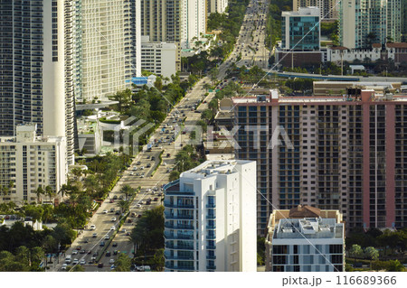 Expensive highrise hotels and condos on Atlantic ocean shore in Sunny Isles Beach city and busy street traffic. American tourism infrastructure in southern Florida 116689366