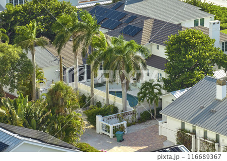Expensive american residential house with rooftop covered with solar photovoltaic panels for producing of clean ecological electrical energy in suburban rural area. Concept of autonomous home 116689367