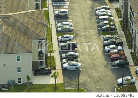 Cars parked on parking place of new apartment condos in Florida suburban area. Family housing in quiet neighborhood. Real estate development in american suburbs 116689495