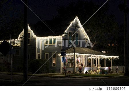 Brightly illuminated christmas decorations on front yard porch of florida family home. Outside decor for winter holidays 116689505