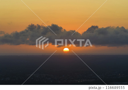 Amazing sunset skyscape. Evening sky with bright colorful orange and yellow clouds over dark landscape 116689555