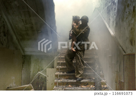 Rescuer with a child walks down the steps in a destroyed house Rescuer with a child walks down the steps in a destroyed house 116691073