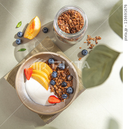 Natural  diet yogurt with homemade granola; peach, strawberry and blueberry in a bowl and jar  116691676