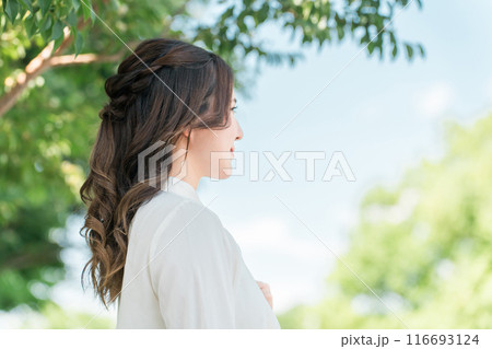 街路樹の下にいる笑顔のビジネスウーマンの横顔 116693124