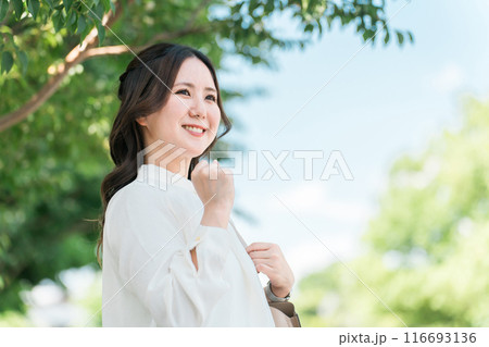 街路樹の下でガッツポーズをするビジネスウーマン 116693136