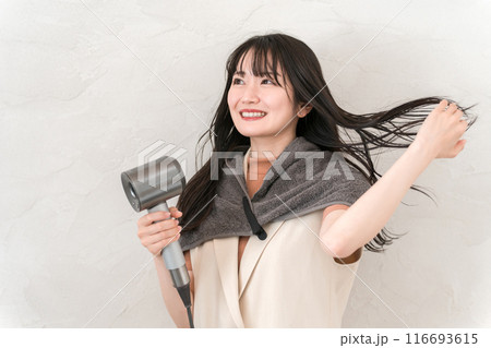 ヘアドライヤーでヘアブロー・髪の毛を乾かす女性（ヘアケア） 116693615