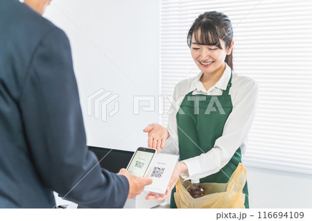レジスター・会計・精算でQRコードを提示するコンビニ・スーパーマーケットの女性店員 116694109
