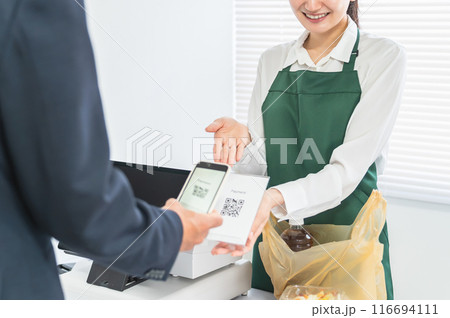 レジスター・会計・精算でQRコードを提示するコンビニ・スーパーマーケットの女性店員 レジスター・会計・精算でQRコードを提示するコンビニ・スーパーマーケットの女性店員 116694111