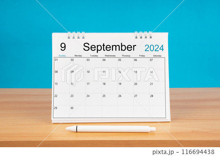 September monthly desk calendar for 2024 year and pen on wooden table with blue background. September monthly desk calendar for 2024 year and pen on wooden table with blue background. 116694438