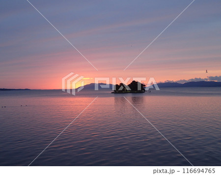 島根県松江市と出雲市にまたがる汽水湖である宍道湖に唯一、浮かぶ島である嫁ヶ島(よめがしま)の夕景 島根県松江市と出雲市にまたがる汽水湖である宍道湖に唯一、浮かぶ島である嫁ヶ島(よめがしま)の夕景 116694765