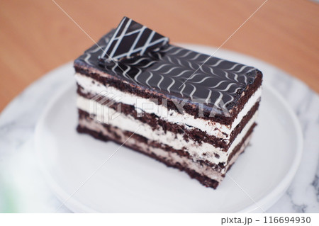 A rectangular layered chocolate cake with white cream layers 116694930