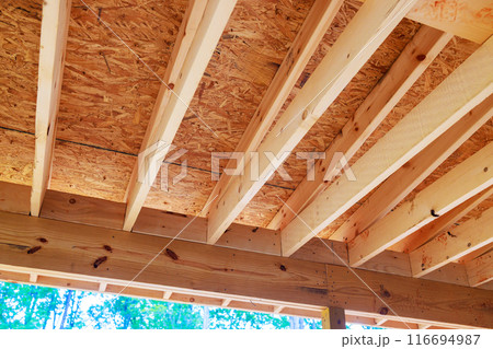 New homes are constructed using wooden frame beams to frame roof trusses 116694987
