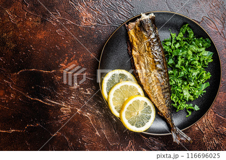 Grilled Mackerel Scomber fish on a plate with greens and lemon. Dark background. Top view. Copy space Grilled Mackerel Scomber fish on a plate with greens and lemon. Dark background. Top view. Copy space 116696025