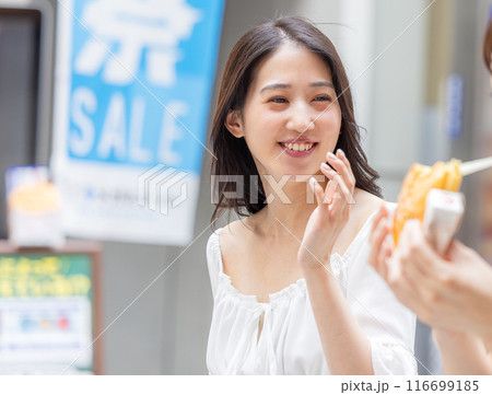 観光をしながら食べ歩きをする若い女性 観光をしながら食べ歩きをする若い女性 116699185