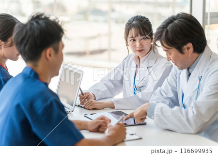 真剣な表情でカンファレンスを開く男女の医療スタッフ 116699935