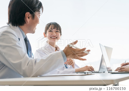 医局のカンファレンスで男性医師の話を聞く女性医師(教授・助手) 医局のカンファレンスで男性医師の話を聞く女性医師(教授・助手) 116700150