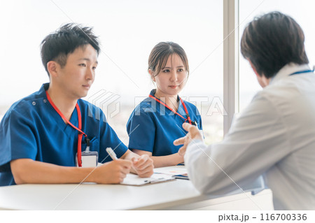 医局でカンファレンス・打ち合わせ・ミーティングする男女の看護師・技師・作業療法士・理学療法士・医師 116700336