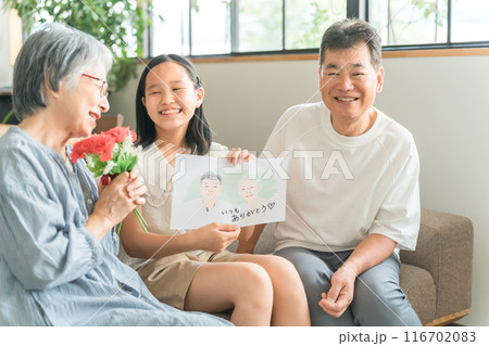 祖父母に敬老の日のお祝いに似顔絵をプレゼントする孫・女の子 祖父母に敬老の日のお祝いに似顔絵をプレゼントする孫・女の子 116702083