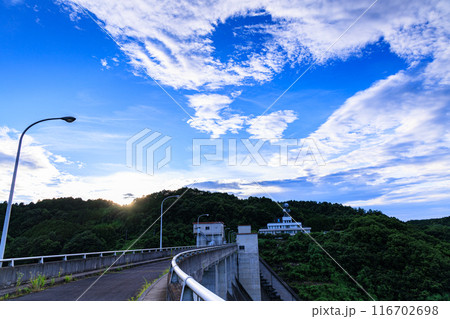 2024年夏布目ダムの夕景ダム堰堤の向こう側の山並みで最後の光を放つ夕日と上空で渦をまくようろこ雲① 2024年夏布目ダムの夕景ダム堰堤の向こう側の山並みで最後の光を放つ夕日と上空で渦をまくようろこ雲① 116702698