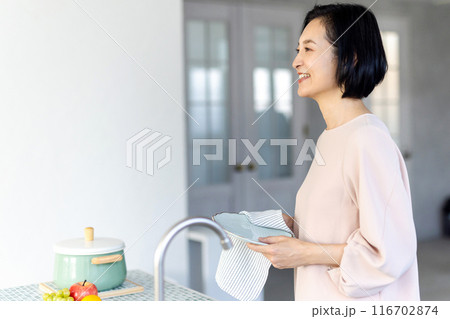 お皿拭きをするミドル女性 116702874