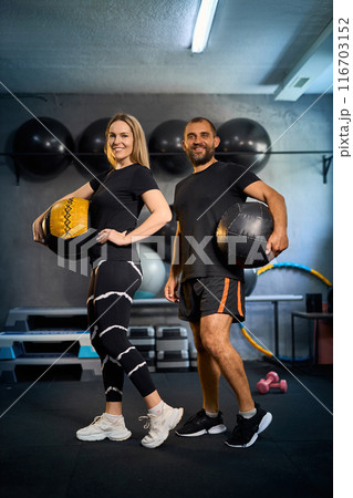 Sporty couple exercising together in gym. 116703152