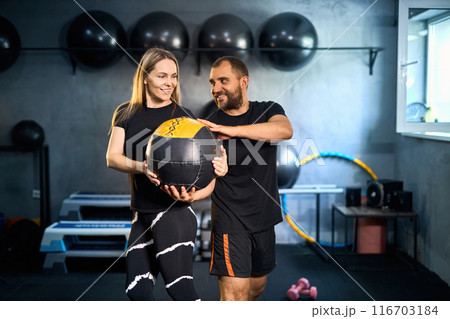 Sporty couple exercising together in gym. Sporty couple exercising together in gym. 116703184